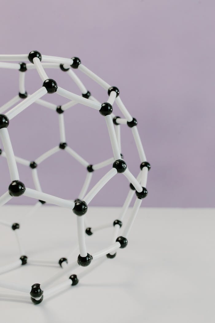 services-01 Close-up of a geometric molecular structure model against a pastel background.